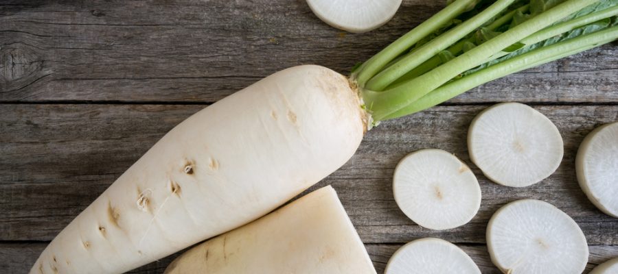 white-radish-sliced-on-wooden-table-600387296
